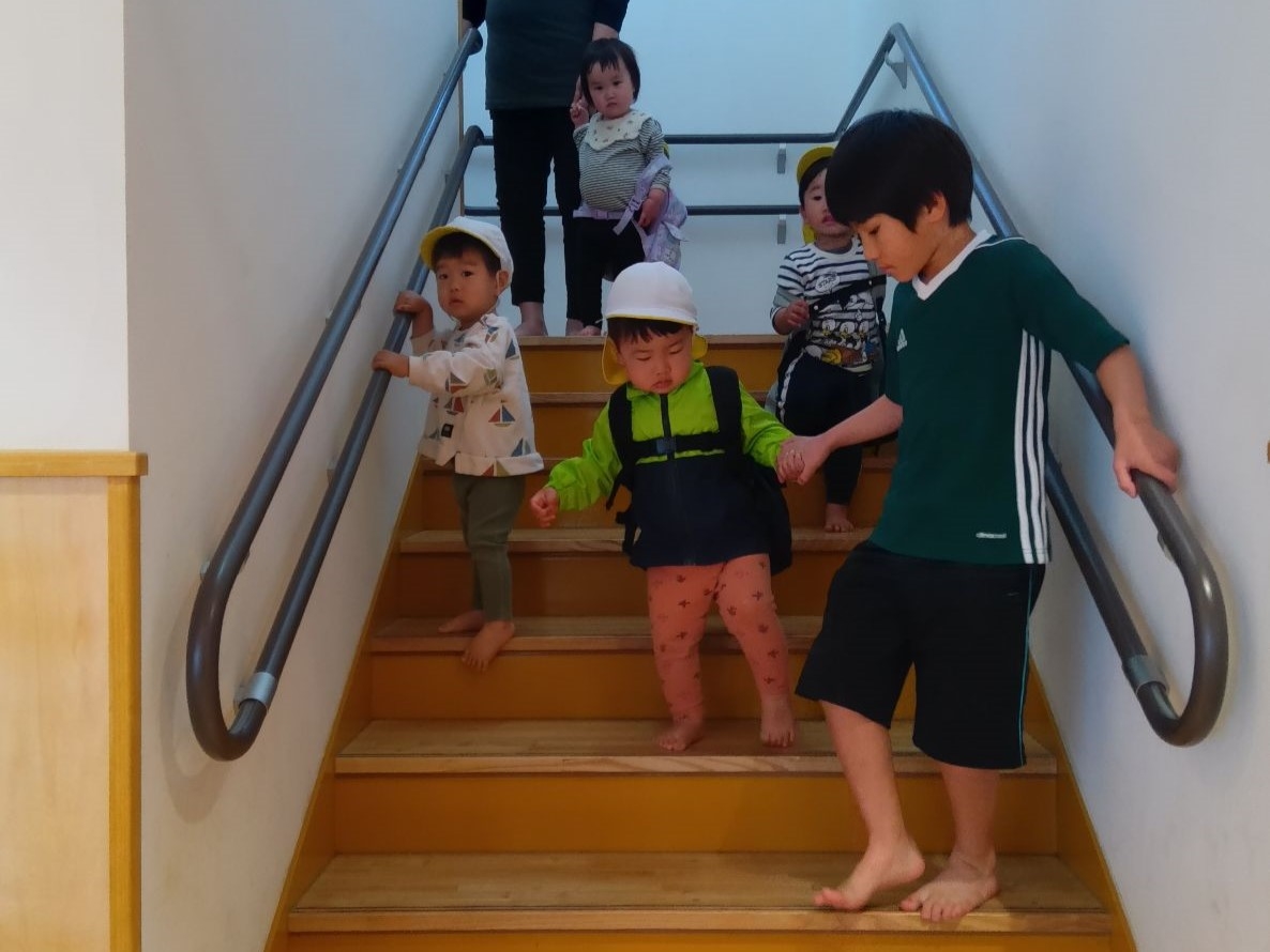 小さな子の階段昇降のサポートをする小学生