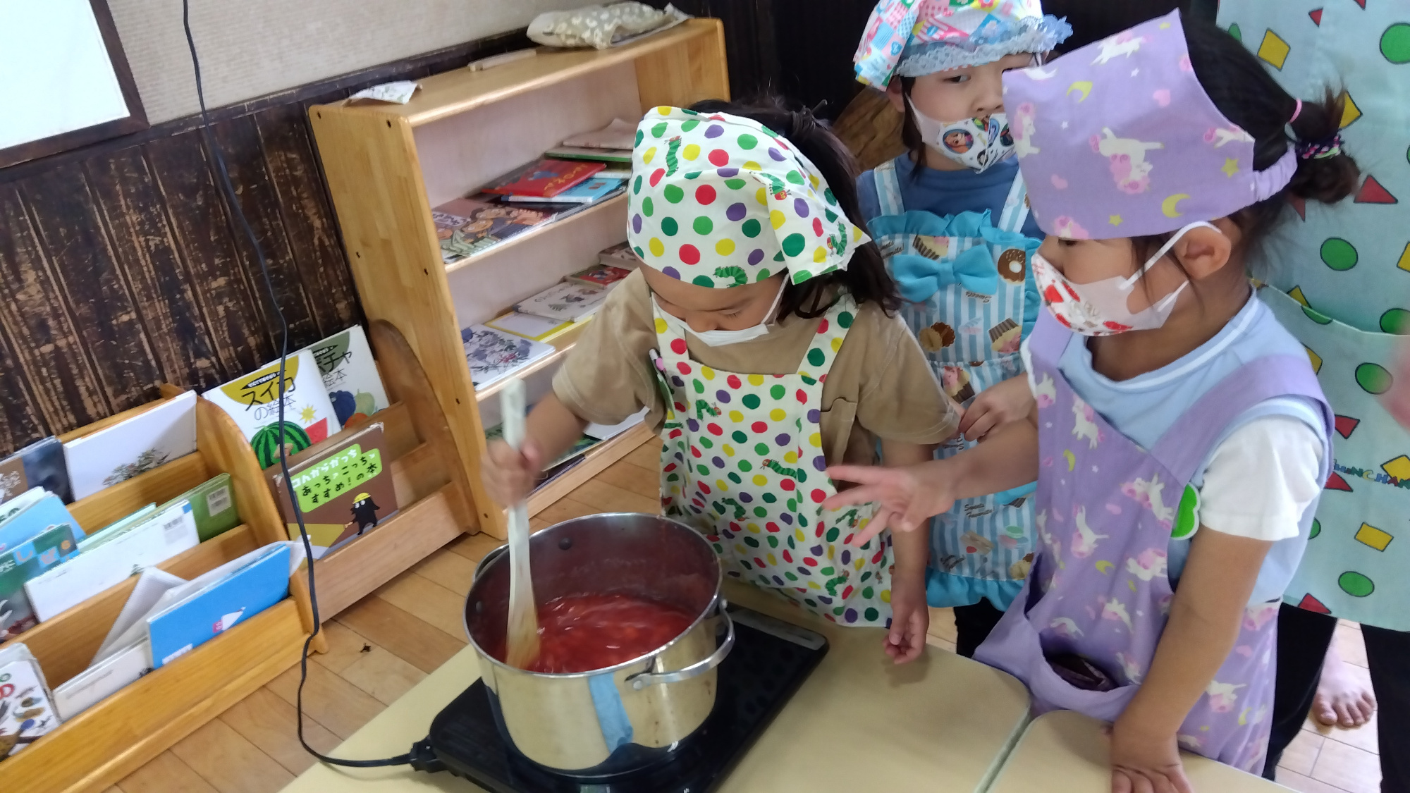 鍋でいちごを煮詰める子どもたち