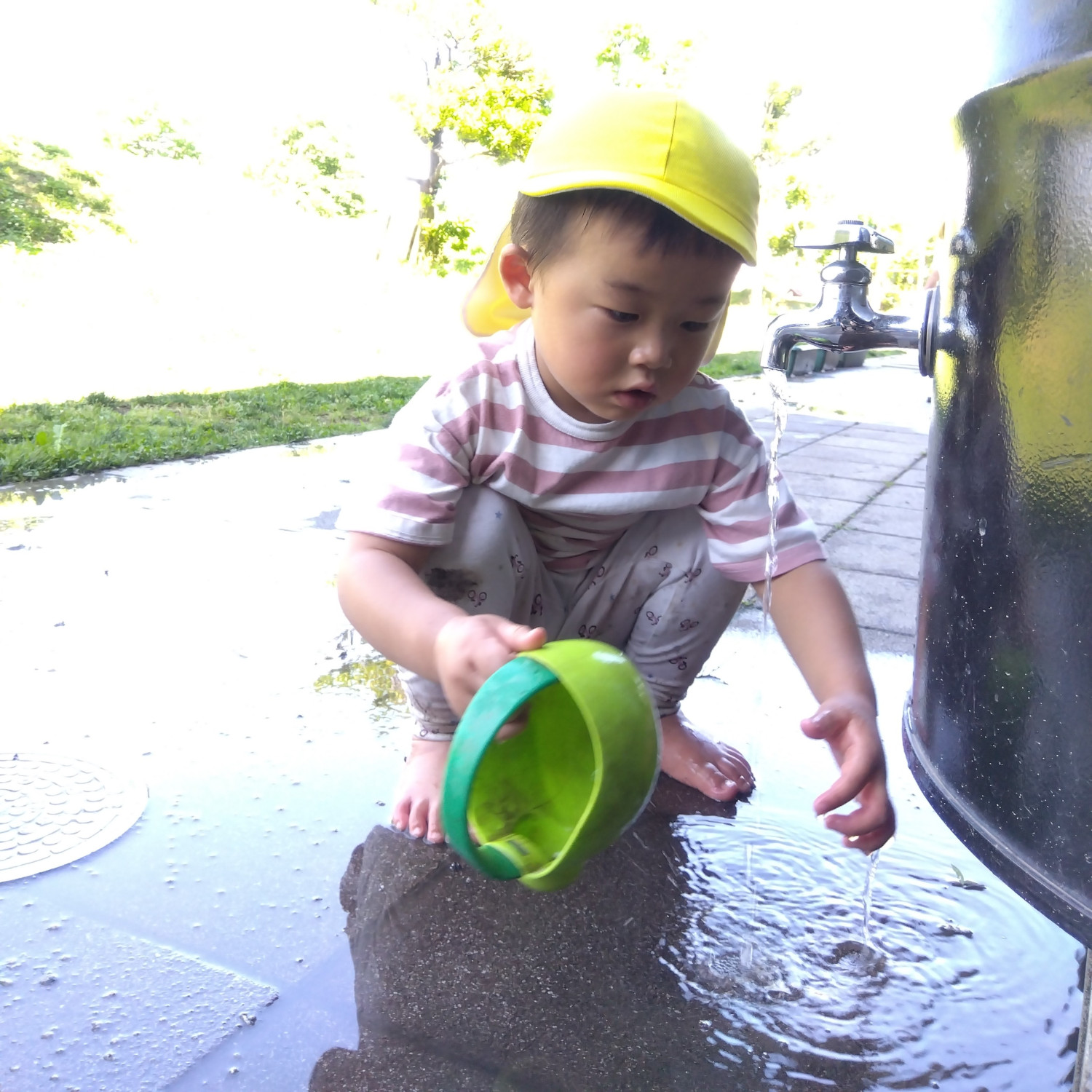 ドラム缶の水で遊ぶ子ども