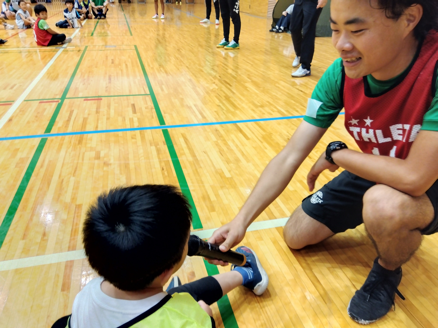 子どもとコミュニケーションをとるコーチ