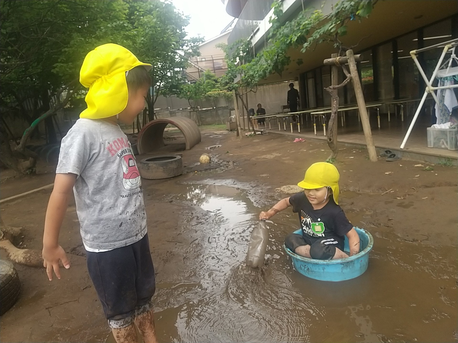 園庭で泥遊びをする子どもたち