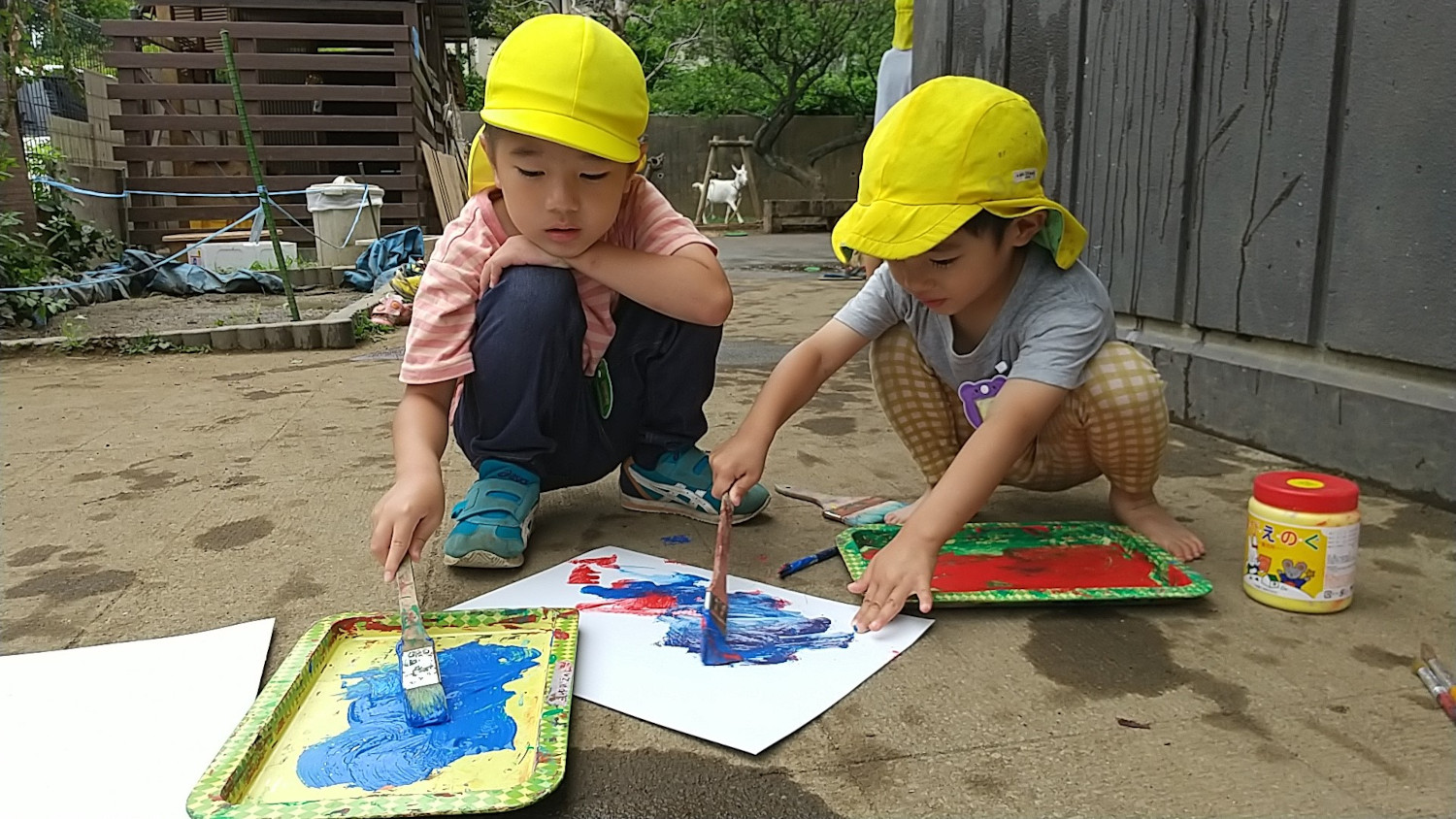 園庭で絵の具遊びをする子どもたち