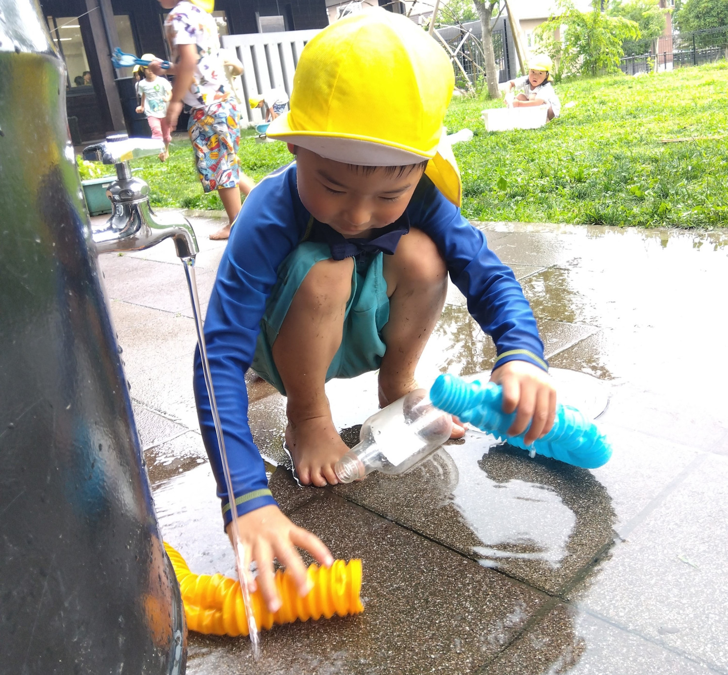 容器を使って水遊びをする様子