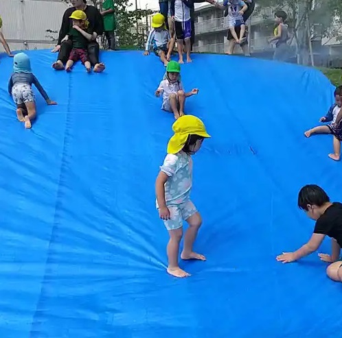 どろんこスライダーで遊ぶ子どもたち