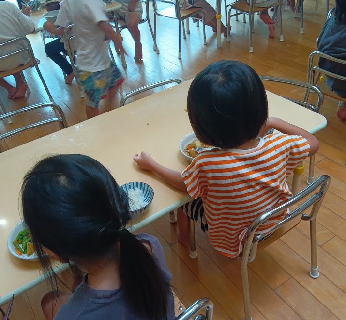 子どもたちが横並びで食事をとる様子