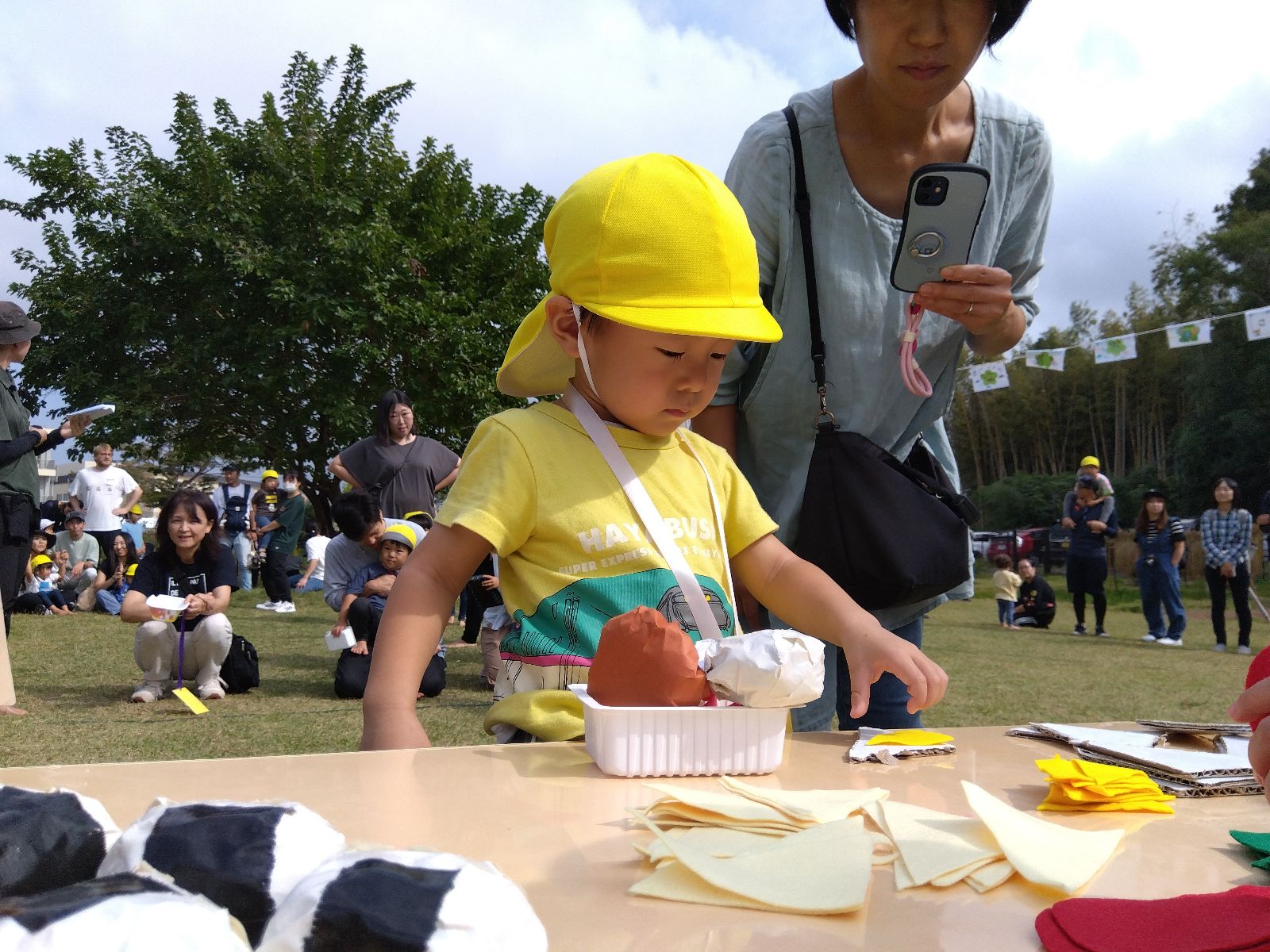 運動会の競技でお弁当作りをする親子