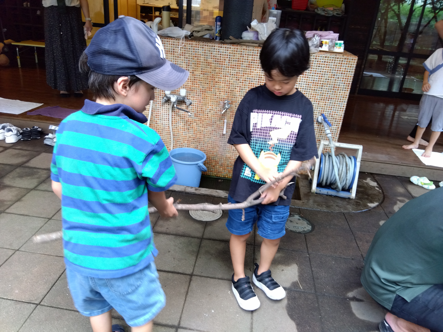 協力して枝を折ろうとする子どもたち