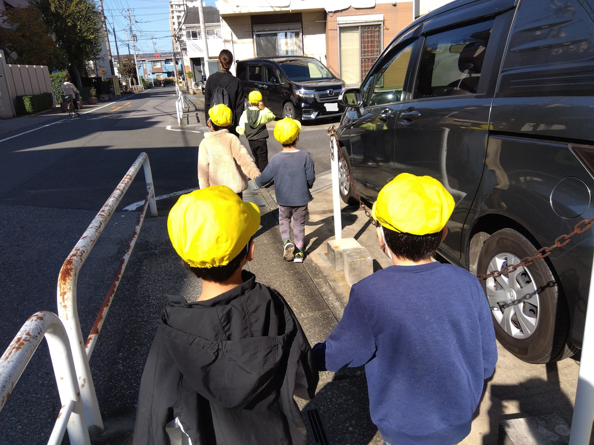 手をつないで歩道を歩く子どもたち