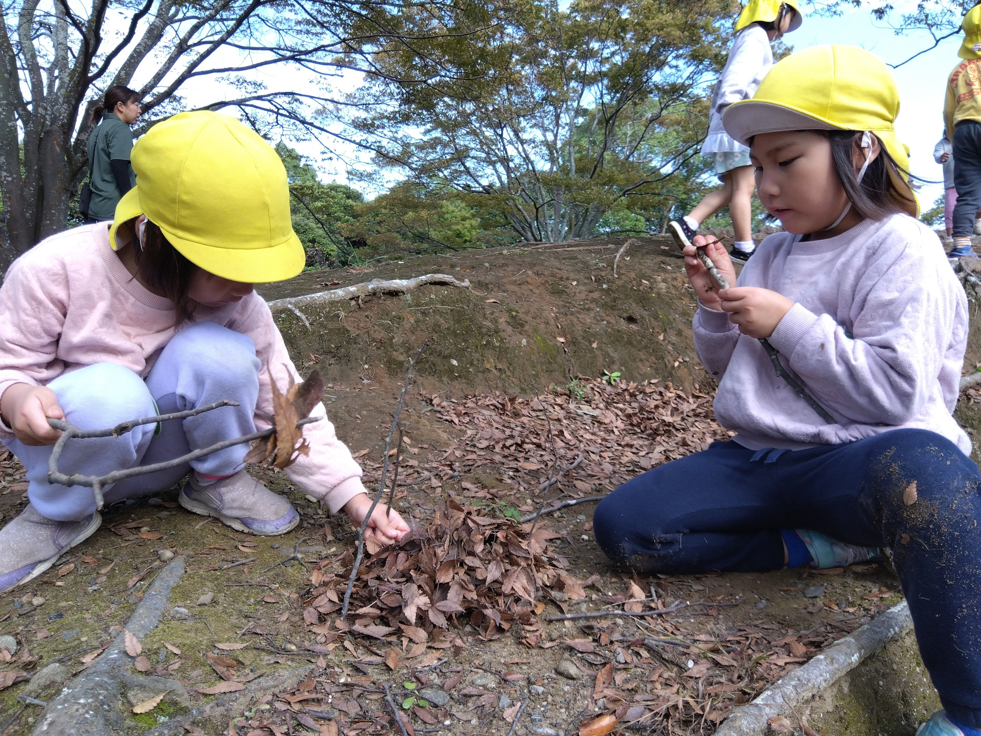 葉っぱでキャンプごっこをする子どもたち