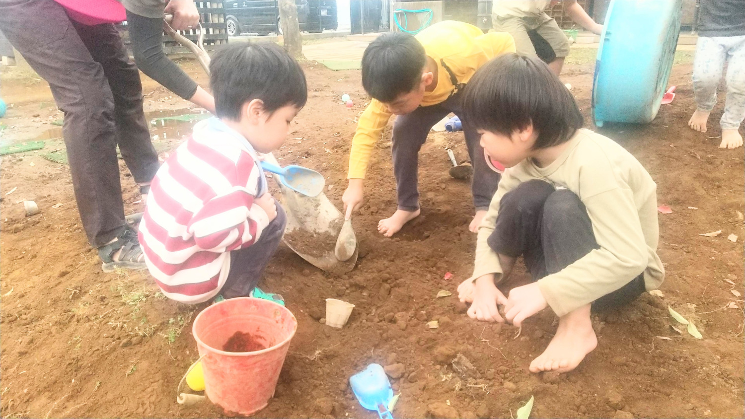 シャベルで土を掘る子どもたち