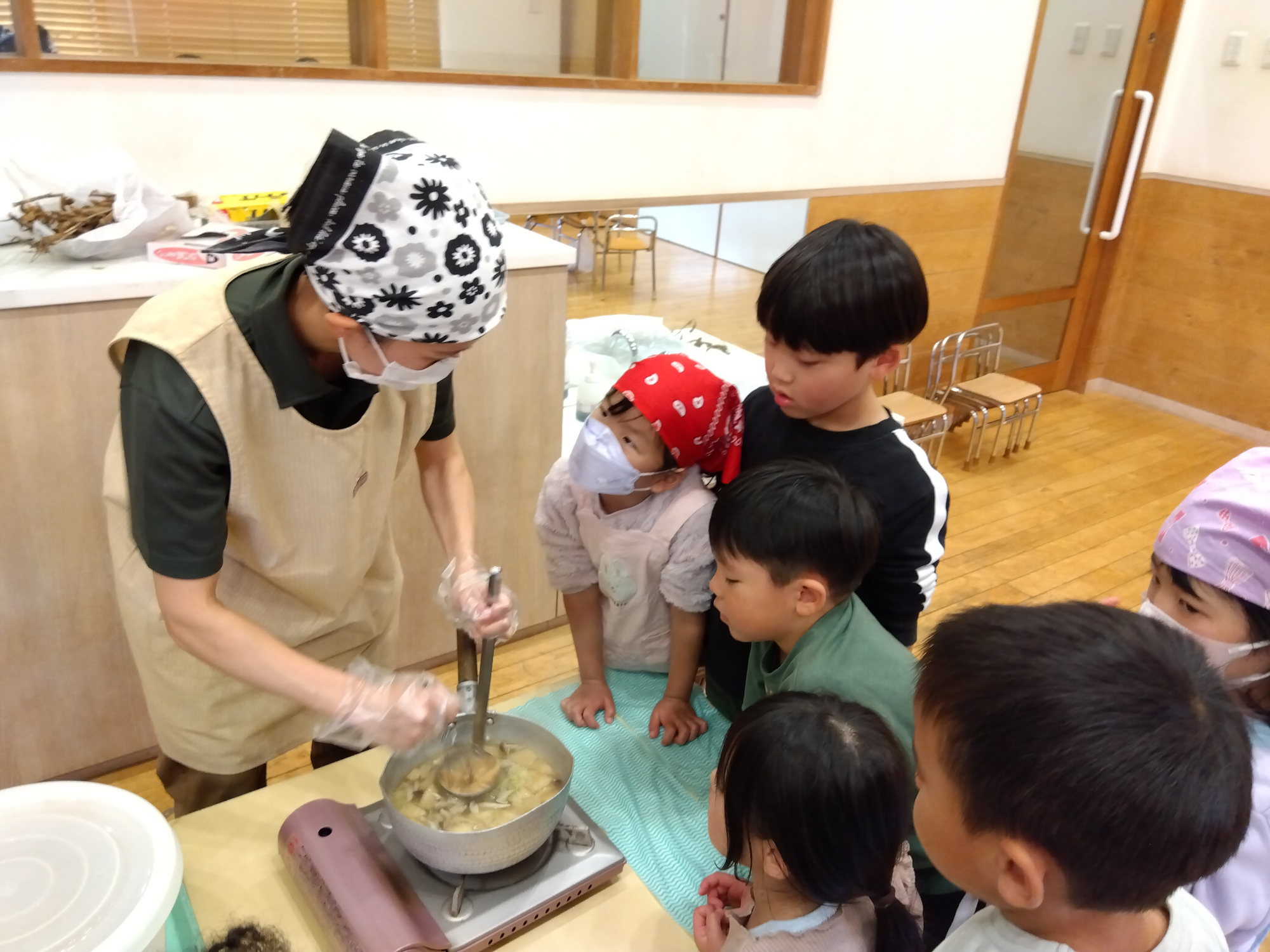 完成した味噌汁とそれを囲む子どもたちの様子