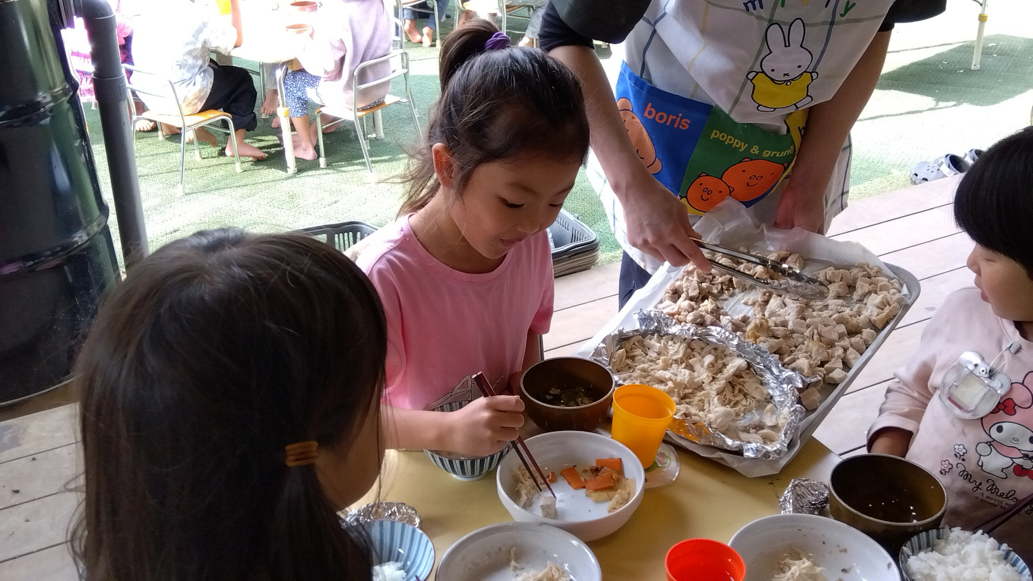 焼いた鶏肉を食べる子どもたち