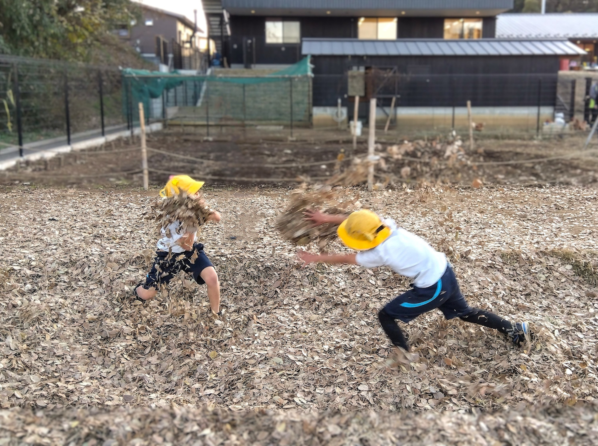 落ち葉で遊ぶ子どもたち