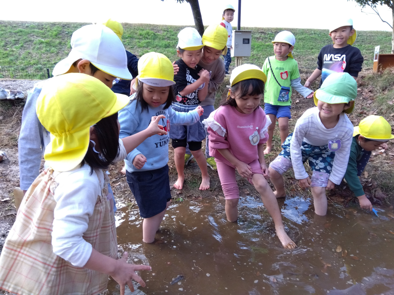 水たまりに足を入れる子どもたち