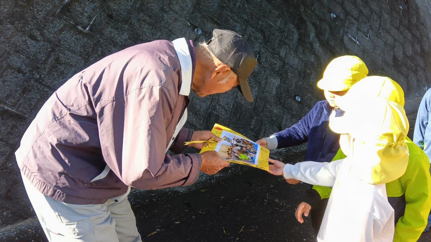 しめ縄作りの講師の方にお礼を渡す子どもたち