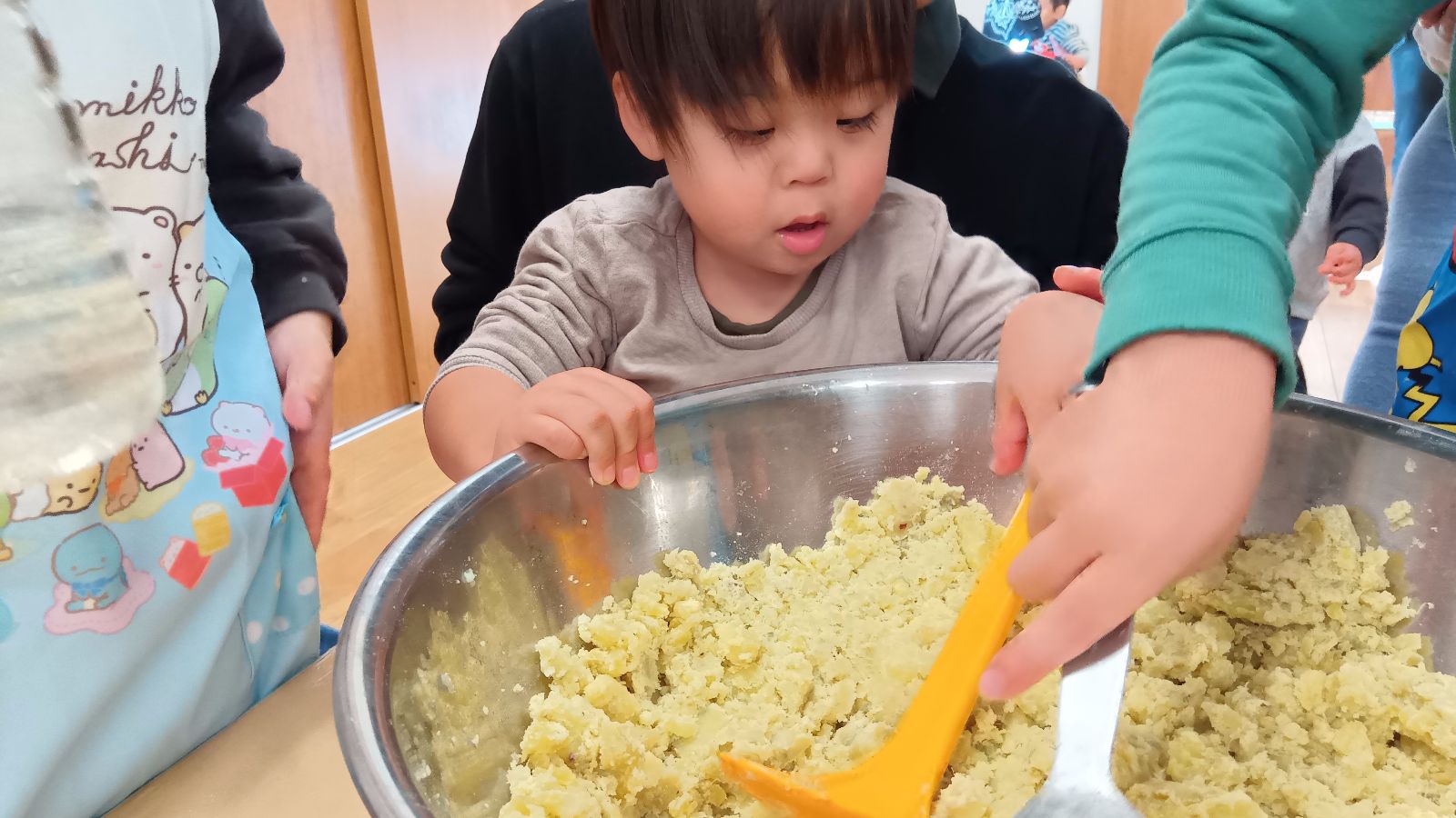 調理される芋を見つめる子ども