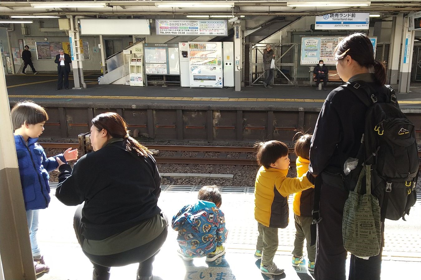 駅のホームで電車を待つ子どもたち