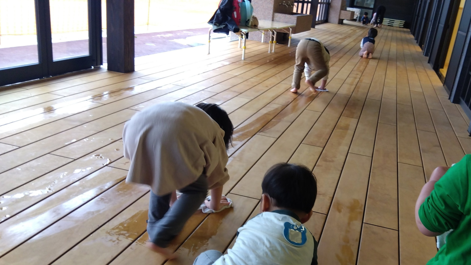 縁側を雑巾がけする子どもたち