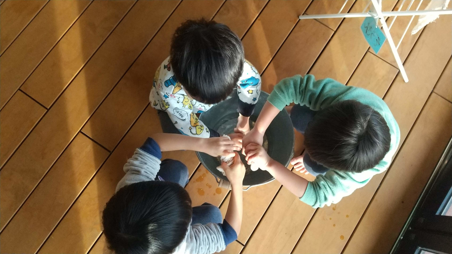 バケツの上で雑巾を絞る子どもたち