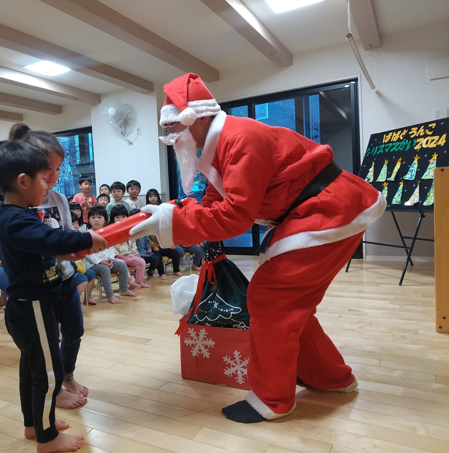 サンタクロースからプレゼントを受け取る子ども