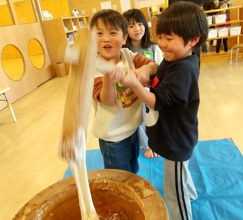協力しながら餅をつく子どもたち