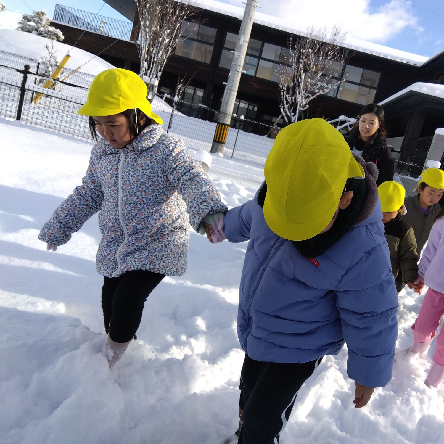 手をつないで雪道を歩く子どもたち