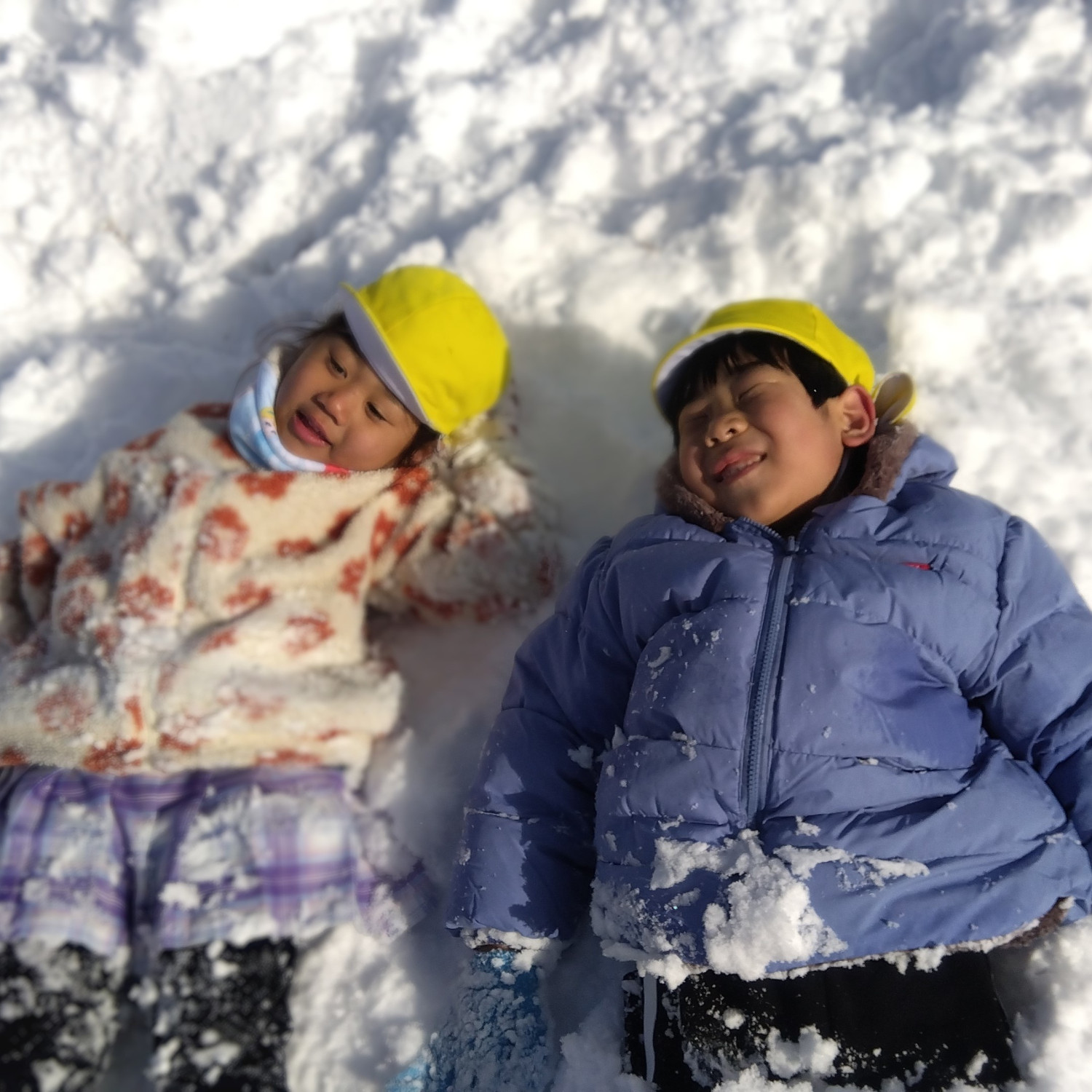 雪の上に寝っ転がる子どもたち