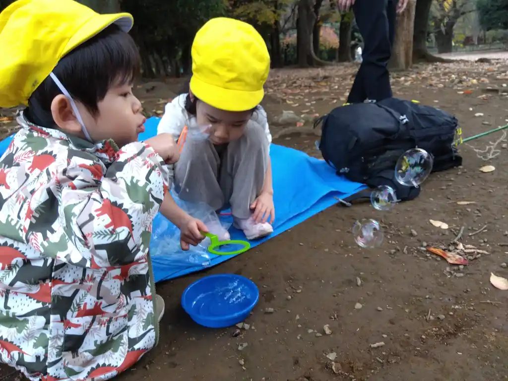 公園でしゃぼん玉で遊ぶ子どもたち