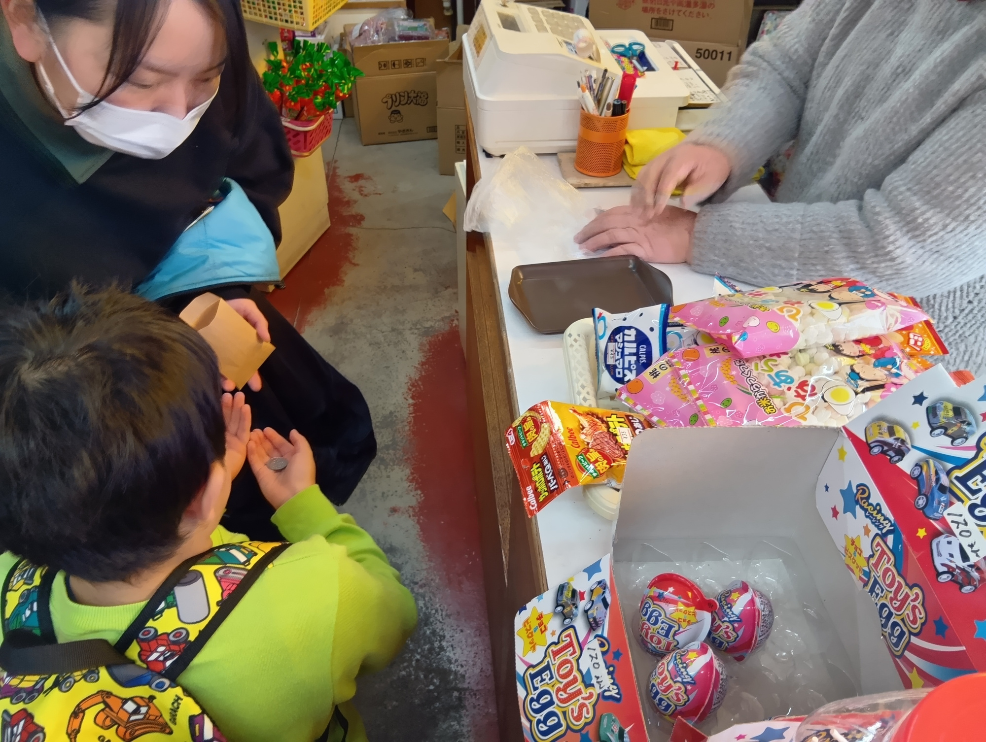 駄菓子屋でお金を払う子どもの様子