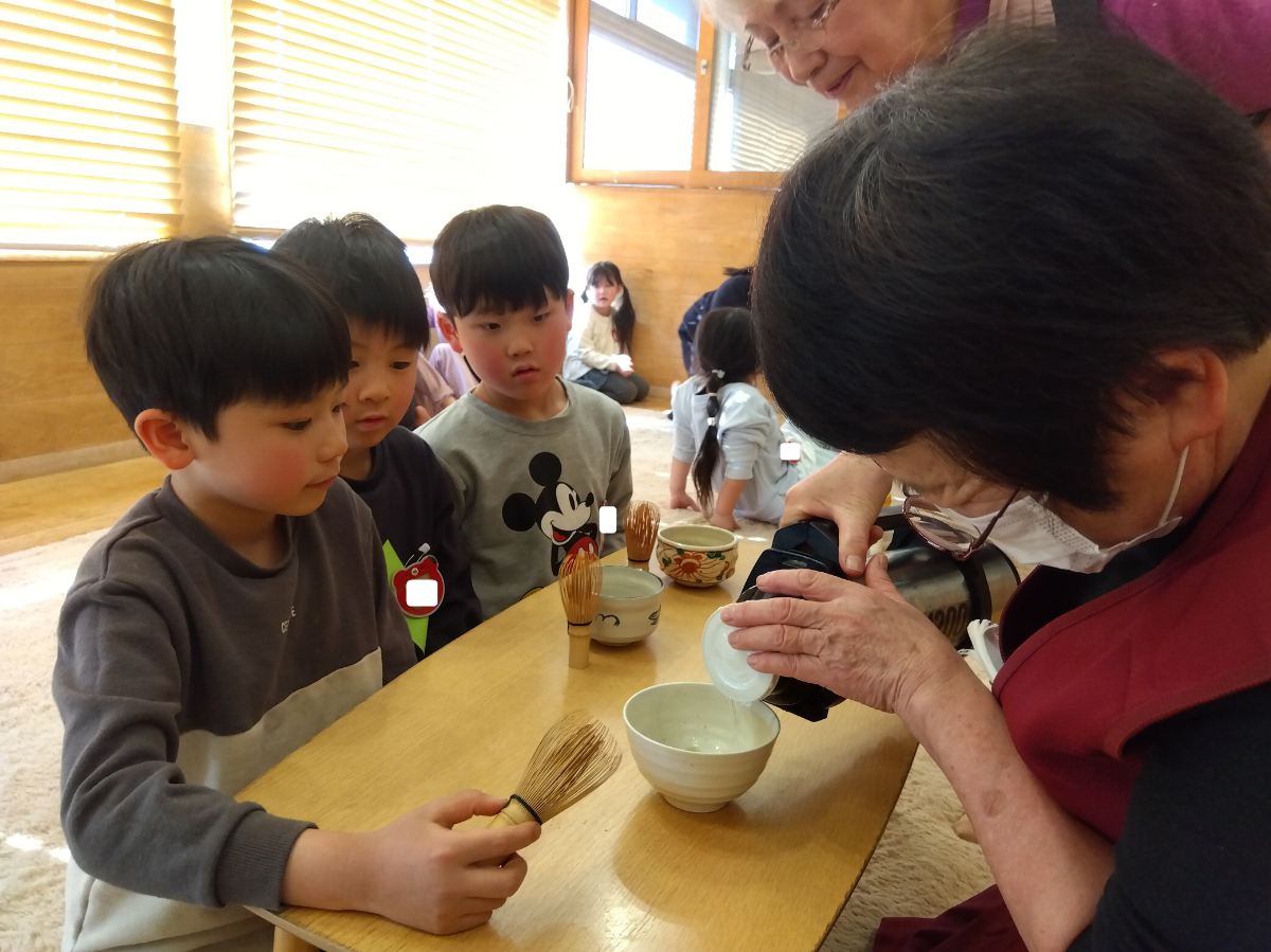 お茶を入れる姿を見つめる子どもたち