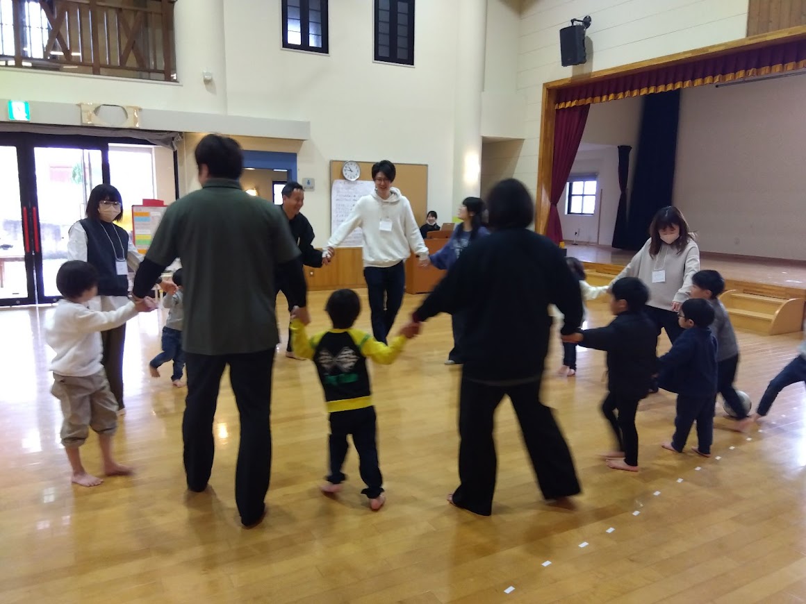 親子で手をつないで輪になっている様子