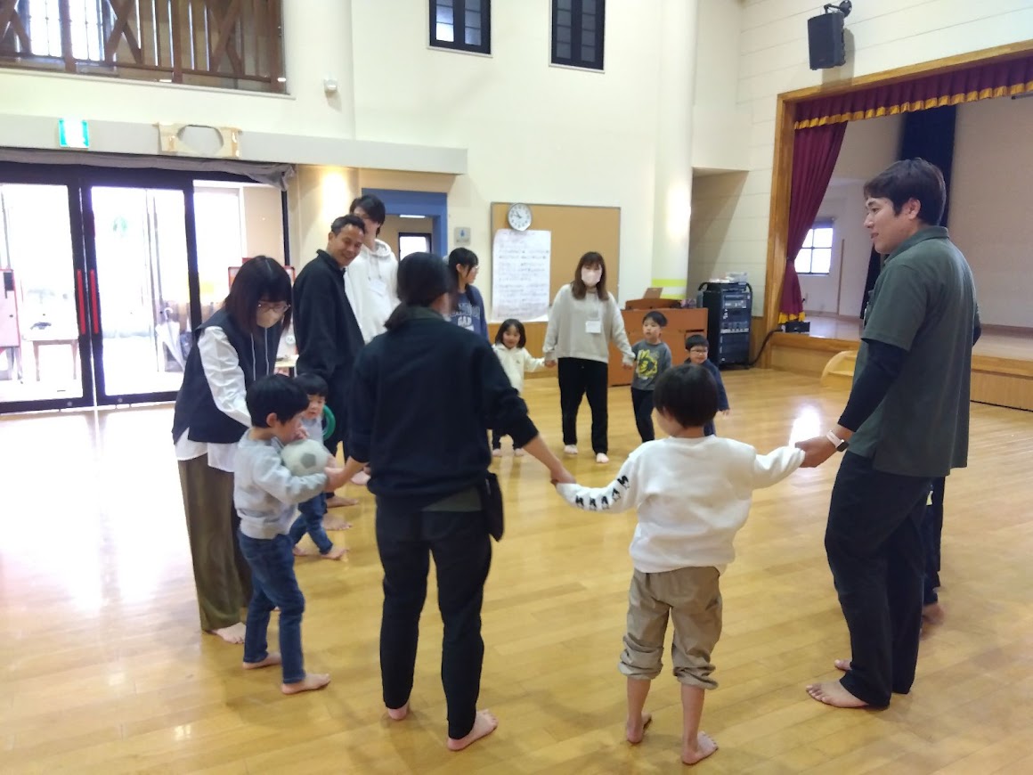 親子で手をつないで輪になっている様子