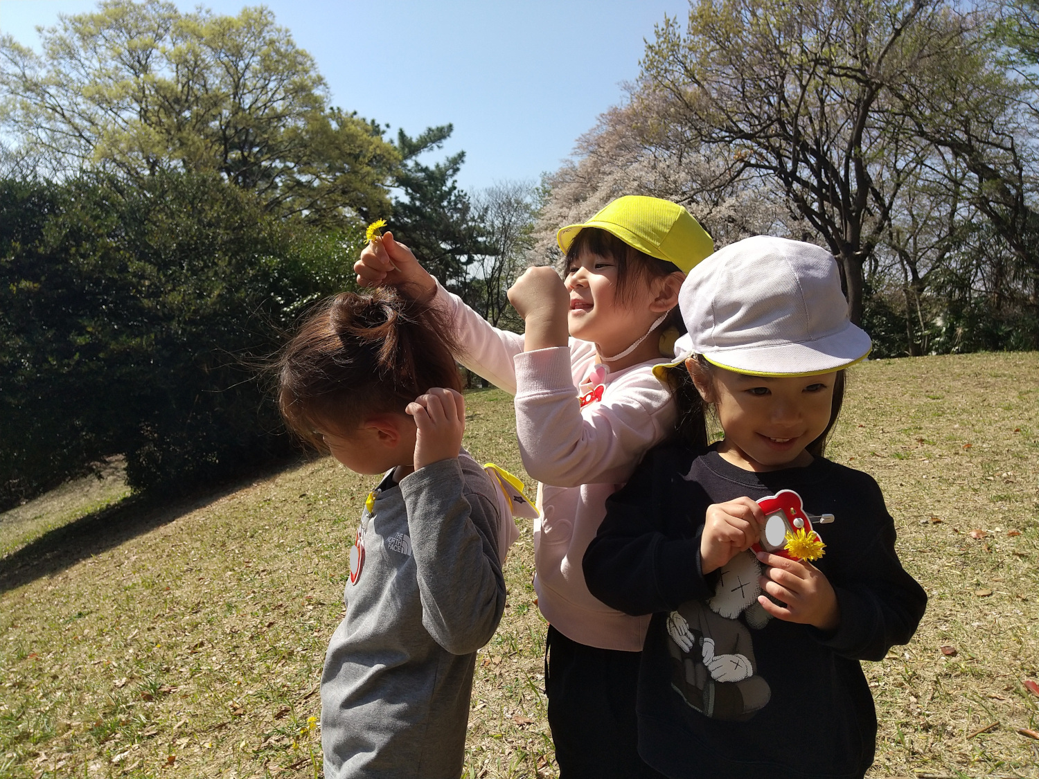 摘んだ草花で遊ぶ子どもたち