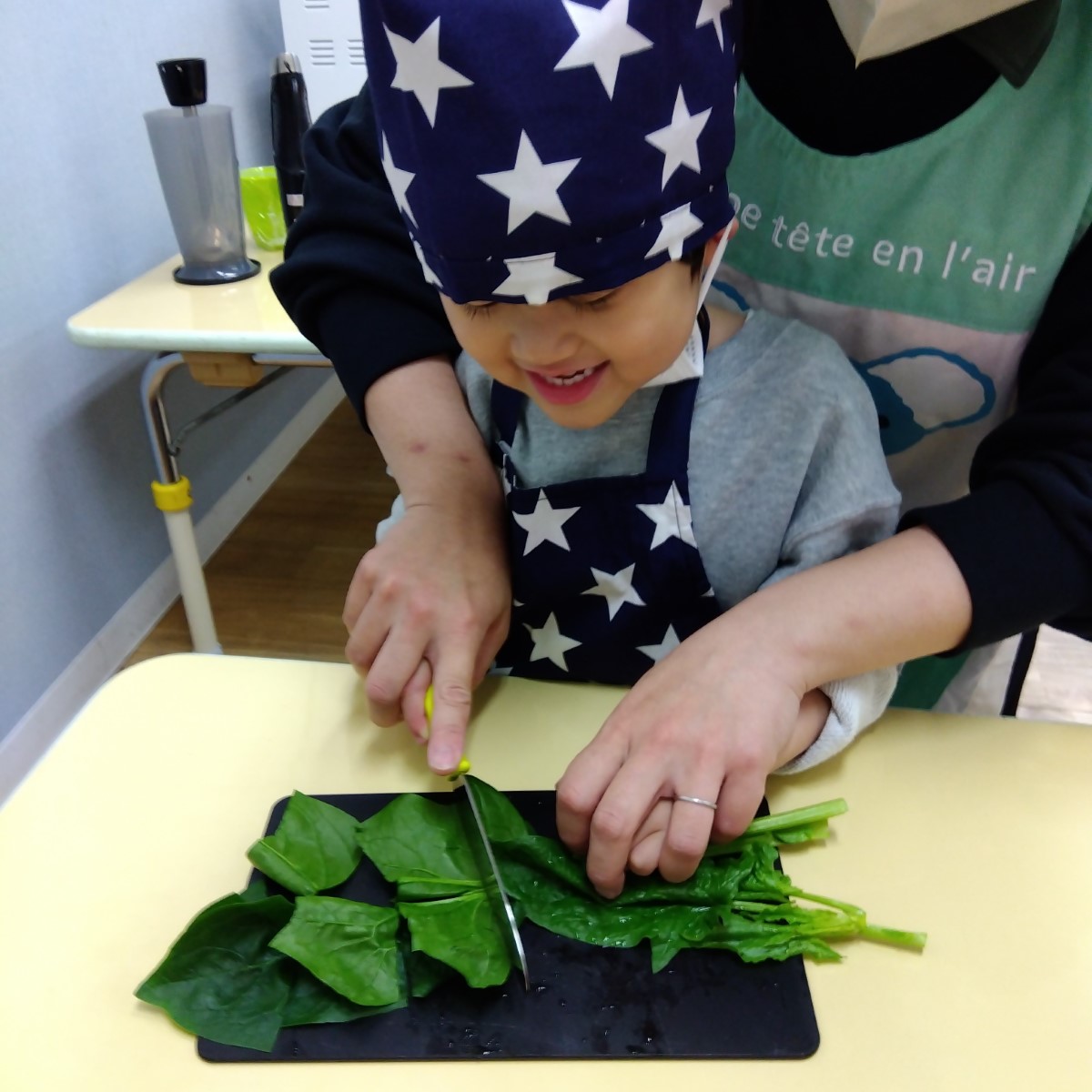 包丁でホウレンソウを切る子ども