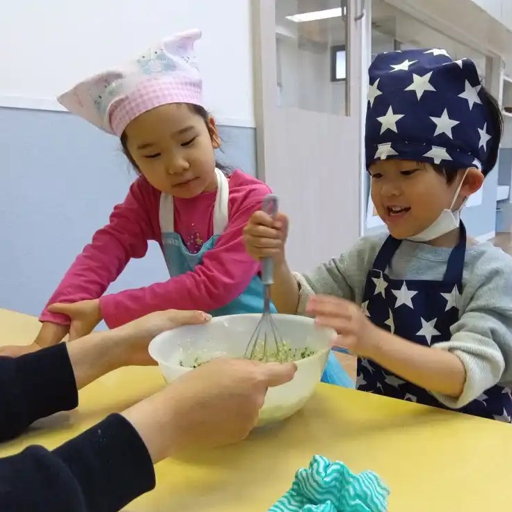 パンケーキの生地を混ぜる子ども